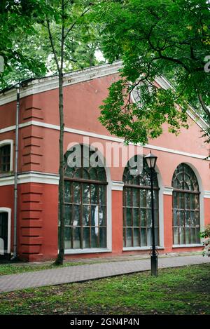 Small pink house with a large arched window and tiled roof. Stock Photo