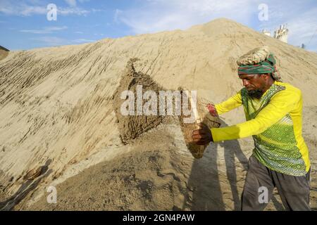 Dhaka, Bangladesh. 22nd Sep, 2021. A Bangladeshi worker unloads sand on the banks of the Buriganga River in Dhaka, Bangladesh, September 22, 2021. (Credit Image: © Suvra Kanti Das/ZUMA Press Wire) Stock Photo