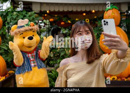 Hong Kong, China. 20th Sep, 2021. A visitor takes a selfie while maintaining social distancing rules with Disney Winnie the Pooh bear character during the seasonal Halloween theme at the Disneyland Resort in Hong Kong in Hong Kong on September 20, 2021. Credit: SOPA Images Limited/Alamy Live News Stock Photo