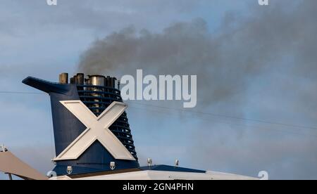 Southampton, England, UK. 2021. Ship's funnel and pipe releasing black smoke into a blue sky. Stock Photo