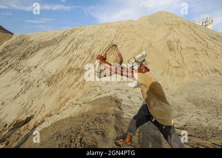 Dhaka, Bangladesh. 22nd Sep, 2021. A Bangladeshi worker unloads sand on the banks of the Buriganga River in Dhaka, Bangladesh, September 22, 2021. (Credit Image: © Suvra Kanti Das/ZUMA Press Wire) Stock Photo