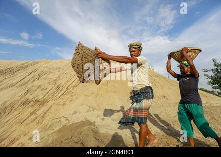 Dhaka, Bangladesh. 22nd Sep, 2021. A Bangladeshi worker unloads sand on the banks of the Buriganga River in Dhaka, Bangladesh, September 22, 2021. (Credit Image: © Suvra Kanti Das/ZUMA Press Wire) Stock Photo