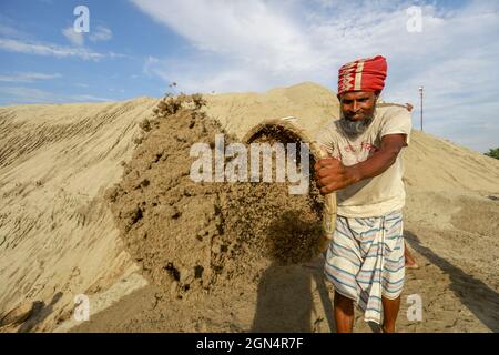 Dhaka, Bangladesh. 22nd Sep, 2021. A Bangladeshi worker unloads sand on the banks of the Buriganga River in Dhaka, Bangladesh, September 22, 2021. (Photo by Suvra Kanti Das/Sipa USA) Credit: Sipa USA/Alamy Live News Stock Photo