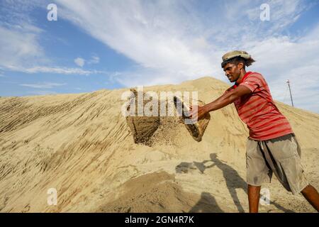 Dhaka, Bangladesh. 22nd Sep, 2021. A Bangladeshi worker unloads sand on the banks of the Buriganga River in Dhaka, Bangladesh, September 22, 2021. (Photo by Suvra Kanti Das/Sipa USA) Credit: Sipa USA/Alamy Live News Stock Photo