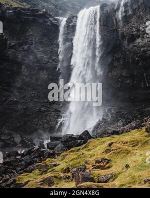 Tourist at the Fossa Waterfall on island Bordoy in the Faroe Islands ...