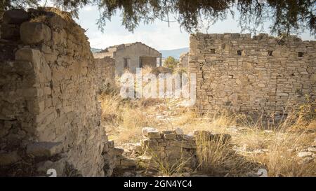 Rural depopulation. Overgrown ruins of abandoned traditional village in Cyprus Stock Photo