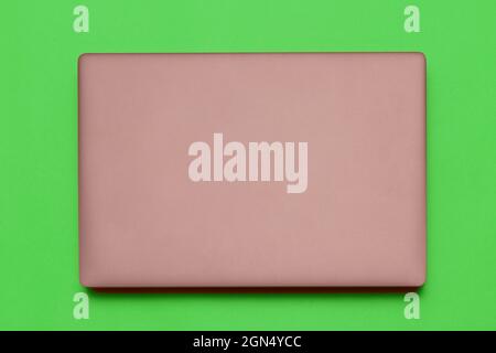 Closed modern silver laptop isolated on green background Stock Photo