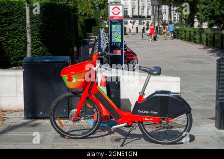 Lime electric bicycle for hire, by a Santander Cycles docking station in Westminster, London, UK. Public bicycle hire scheme in the City of London. Stock Photo
