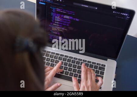 A programmer coding on a laptop in the workplace Stock Photo