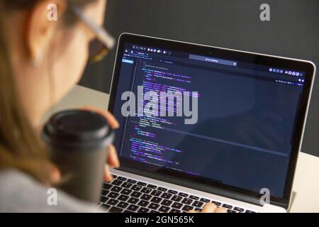 A programmer coding on a laptop in the workplace Stock Photo