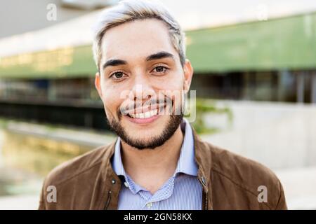 Young hispanic man smiling on camera outdoors  Stock Photo