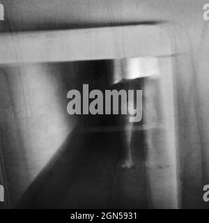 A ghost appears in an old vintage mirror. Phantom apparition. Long exposure. Stock Photo
