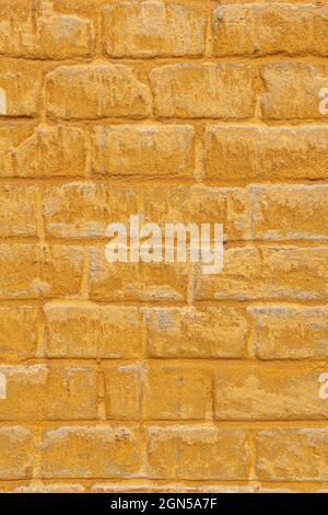 Brick and plaster yellow ochre background. Stock Photo