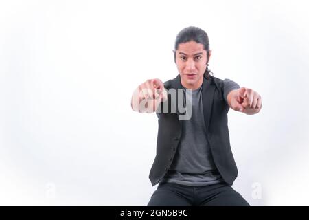 Person with white background. He is pointing with both hands towards the camera. White space. Man gesticulating. Stock Photo
