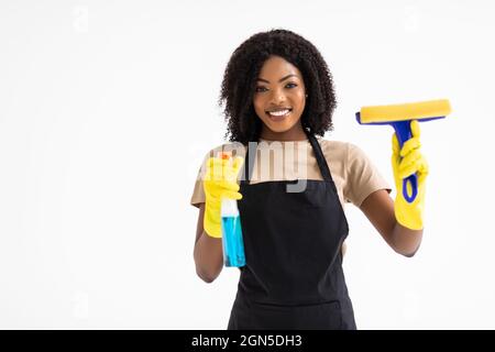 Beautiful young afro woman holding rag and cleanser spray on white background Stock Photo