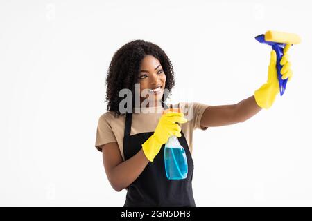 Beautiful young afro woman holding rag and cleanser spray on white background Stock Photo