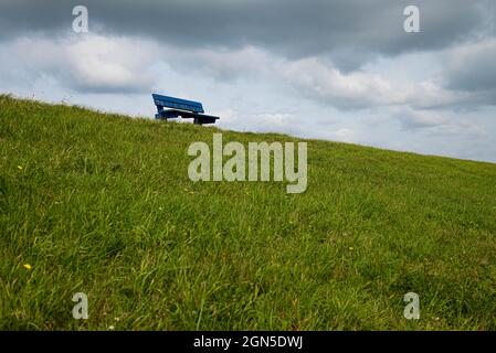 Still life picture of a blue bench on the dike in Petten (The Netherlands) Stock Photo