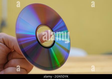 Man hand hold an used cd-rom disk, data storage device technology Stock Photo