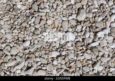 Ionian sea pebble marble stone beach close-up texture. White and beige colors rocks in Greece, Lefkada island coast Stock Photo