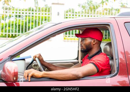 african delivery man driving a car Stock Photo