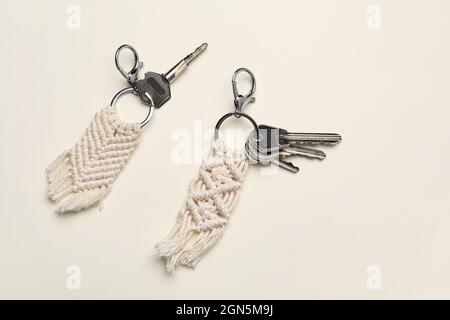 Keys with handmade cotton keychains on light background Stock Photo