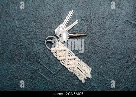 Keys with handmade cotton keychain on dark background Stock Photo