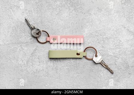 Keys with leather keychains on grey background Stock Photo