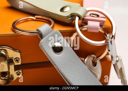 Keys with leather keychains on wooden box, closeup Stock Photo