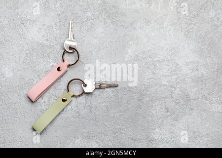 Keys with leather keychains on grey background Stock Photo