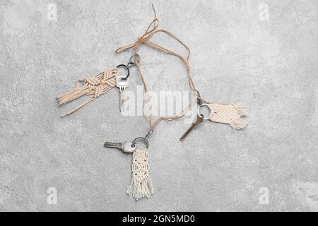 Keys with handmade cotton keychains on grey background Stock Photo
