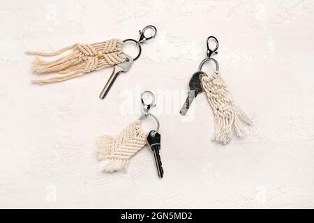 Keys with handmade cotton keychains on light background Stock Photo