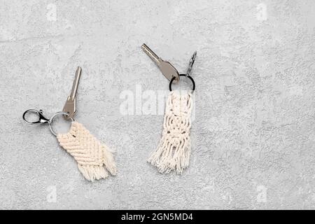 Keys with handmade cotton keychains on grey background Stock Photo