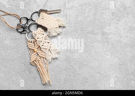 Keys with handmade cotton keychains on grey background Stock Photo