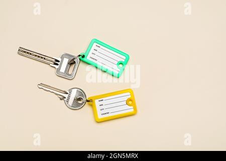Keys with plastic tags on beige background Stock Photo