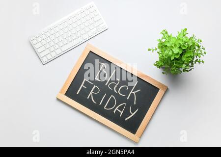 Chalkboard with text BLACK FRIDAY and PC keyboard on light background Stock Photo
