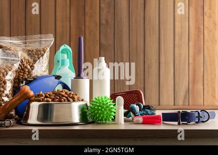 Food and accessories for walk, play and body care for the dog on wooden table. Front view. Horizontal composition. Stock Photo