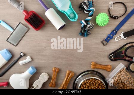 Food and accessories for walk, play and body care for the dog on wooden table frame composition. Top view. Horizontal composition. Stock Photo