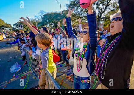 People wave for Mardi Gras beads as a Mardi Gras float passes during the Joe Cain Day Mardi Gras parade, Feb. 7, 2016, in Mobile, Alabama. Stock Photo