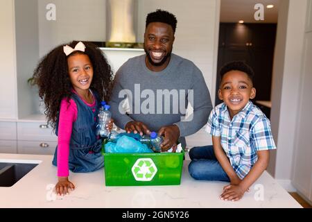 African american father and children segregating rubbish in kitchen Stock Photo