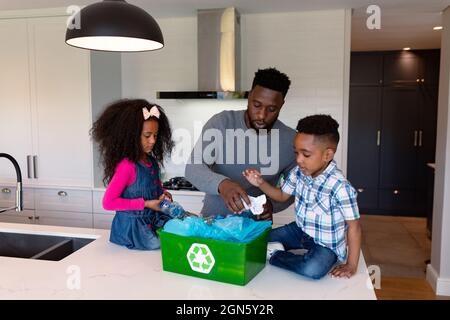 African american father and children segregating rubbish in kitchen Stock Photo