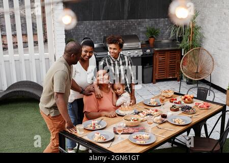 Portrait of big African-American family celebrating loving grandmother at dinner outdoors, copy space Stock Photo