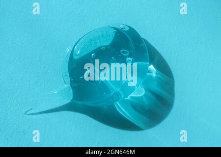 Macro, close up of transparent droplet of skincare product. Aloe vera cleanser with bubbles, lotion smear, styling gel swatch, shampoo drop. Squeezed Stock Photo
