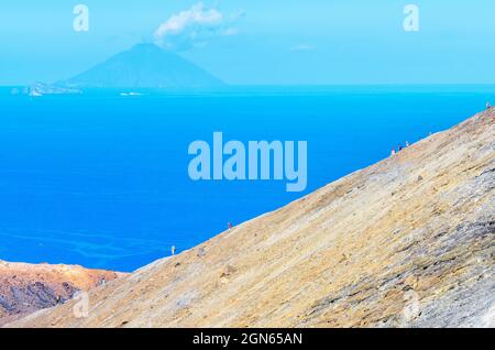 Hikers walking on Gran Crater rim, Vulcano Island, Aeolian Islands, Sicily, Italy Stock Photo