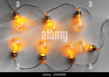Light bulbs illuminated garland on light gray background Stock Photo