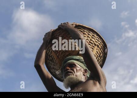 Dhaka, Bangladesh. 22nd Sep, 2021. A labour carries heavy loads of sand balanced on his head in the Bank of Turag River at Dhaka City. Bangladesh Labour earn BDT450 Taka=5.27 USD per day. Credit: SOPA Images Limited/Alamy Live News Stock Photo