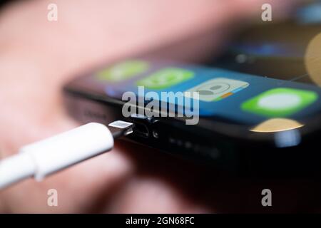 22 September 2021, Lower Saxony, Oldenburg: A Lightning charging plug is inserted into an Apple iPhone. The EU Commission presents a proposal for a uniform mobile phone charging socket. The issue of chargers has preoccupied the EU institutions for more than a decade. In 2009, under pressure from the EU Commission, 14 mobile phone manufacturers - including Apple - agreed on a uniform standard for power supply units in a voluntary commitment. When it comes to the jacks in smartphones and tablet computers, three types remain from what were once several dozen: the now obsolete Micro-USB, the newer Stock Photo