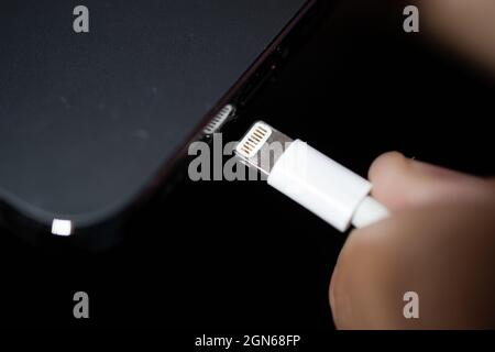 22 September 2021, Lower Saxony, Oldenburg: A Lightning charging plug is inserted into an Apple iPhone. The EU Commission presents a proposal for a uniform mobile phone charging socket. The issue of chargers has preoccupied the EU institutions for more than a decade. In 2009, under pressure from the EU Commission, 14 mobile phone manufacturers - including Apple - agreed on a uniform standard for power supply units in a voluntary commitment. When it comes to the jacks in smartphones and tablet computers, three types remain from what were once several dozen: the now obsolete Micro-USB, the newer Stock Photo