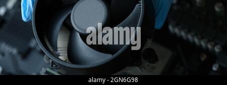 Gloved craftsman installing cooler into video card closeup Stock Photo