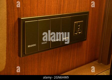 A closeup shot of modern black light switch on wooden wall, interior, style. Stock Photo