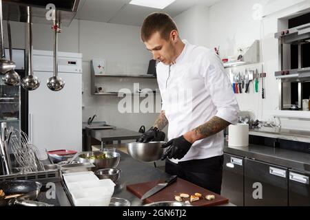 Chef cooking in the modern kitchen in hotel restaurant, preparing shrimp salad Stock Photo